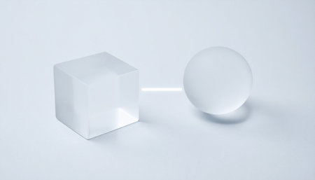 A study in contrasts and harmony. A perfect glass cube representing structure and logic sits beside a smooth sphere symbolizing fluidity and wholeness.の素材