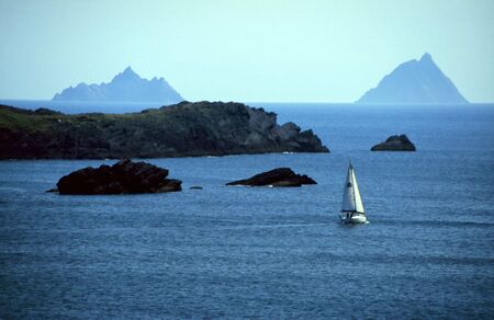 Sailboat in bay near Skellig island, Irelandの写真素材