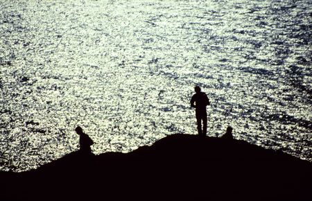 Silhouettes of fishermen by the sea at Valencia Island, Western Irelandの写真素材