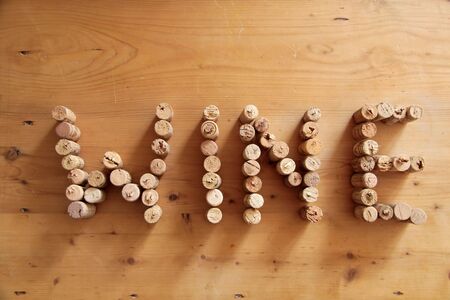 Corks forming the word wine on wooden deskの写真素材