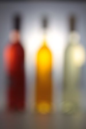 Three wine bottles with backlight and grey backgroundの写真素材