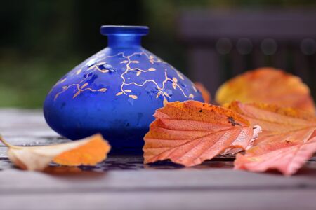 Blue Vase with Autumn decoration on a wooden tableの写真素材
