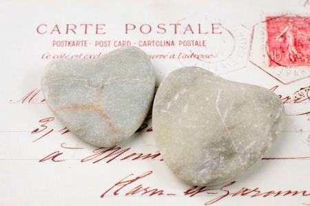 Two light stone hearts with old French  postcardの写真素材