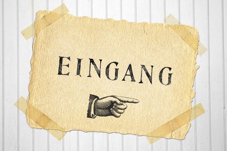 Old paper label entry pasted to white wooden doorの写真素材