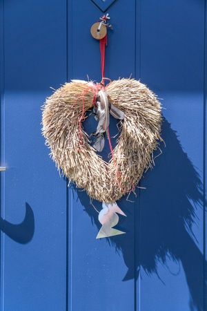 Decorative heart from straw on blue door in Svaneke on Bornholm  Denmarkの写真素材