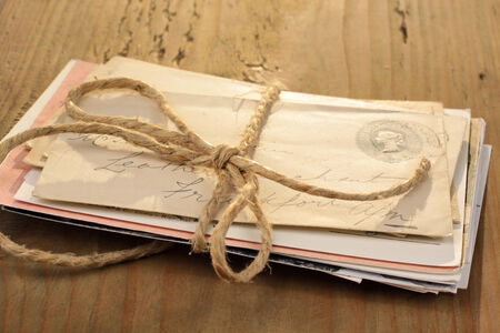Bundle of letters tied with a cord on the old wooden tableの写真素材
