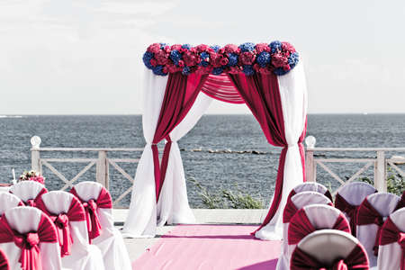 Wedding arch of different flowers on a background of the seaの写真素材
