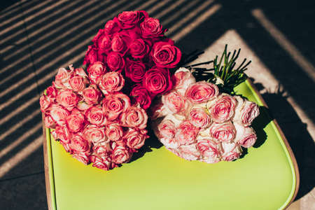 Three bouquet of roses of different colors lie side by side on the sunlightの写真素材
