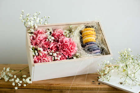 Carnation flowers in a box with a macaroonの写真素材