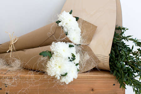 Two bouquets of white chrysanthemums in a paper cornetの写真素材