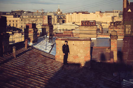Man in a leather jacket on a rooftop in the center of the cityの写真素材