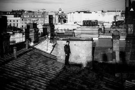 Man in a leather jacket on a rooftop in the center of the cityの写真素材