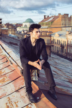 Fashion businessman on a rooftop in the center of the cityの写真素材