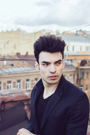 Fashion businessman on a rooftop in the center of the cityの写真素材
