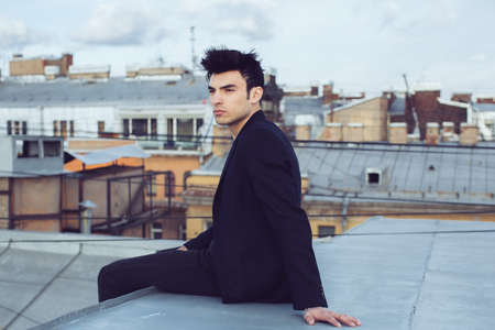 Fashion businessman on a rooftop in the center of the cityの写真素材