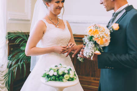 gentle romantic happy couple exchanging wedding rings in wedding palaceの写真素材