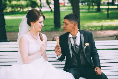 Bride and groom having an ice cream in outdoorの写真素材