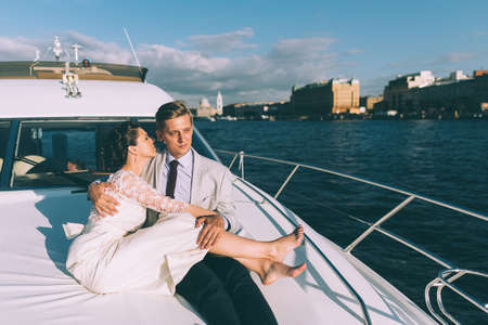 Happy bride and groom on a yacht traveling together on a warm summer dayの写真素材