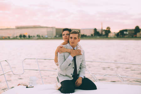 Happy bride and groom on a yacht traveling together on a warm summer dayの写真素材