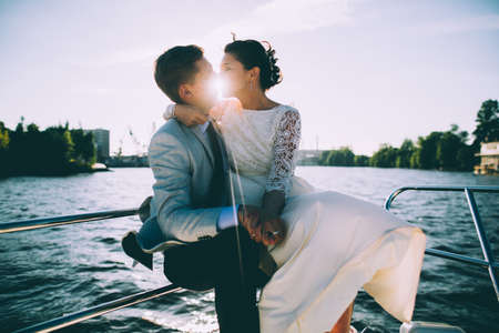Happy bride and groom on a yacht traveling together on a warm summer dayの写真素材