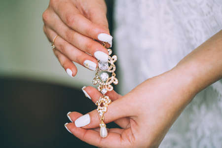 Bride is holding earringsの写真素材