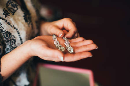 Bride is holding earringsの写真素材