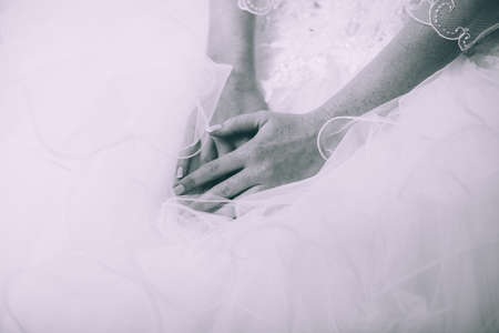 Bride folded her hands in her lap. Beautiful nailsの写真素材