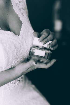 The bride holding in hands a bottle of perfumeの写真素材