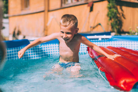 Activities on the pool, children swimming and playing in water, happiness and summertimeの写真素材