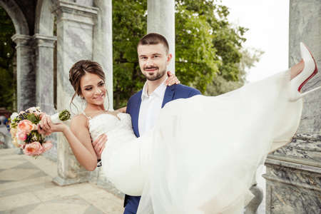 groom holding a bride up in his handsの写真素材