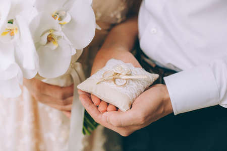Man and woman holding wedding rings close upの写真素材