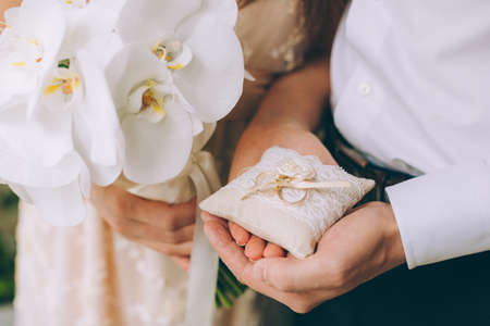 Man and woman holding wedding rings close upの写真素材