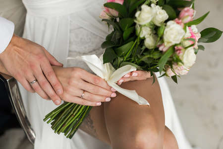 Hands with rings Groom putting golden ring on bride's finger during wedding ceremonyの写真素材