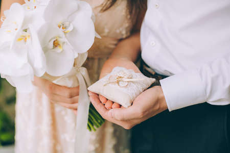 Man and woman holding wedding rings close upの写真素材