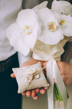 Man and woman holding wedding rings close upの写真素材