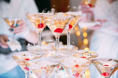 Champagne glasses. Wedding slide champagne for bride and groom. Colorful wedding glasses with champagne. Catering service. Catering bar for celebration. Beauty of bridal interior for weddingの写真素材