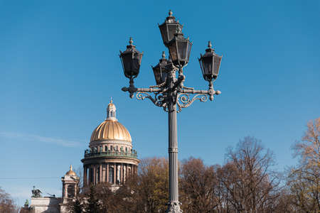 Stylized old lantern, on a background of city and blue sky with cloudsの写真素材