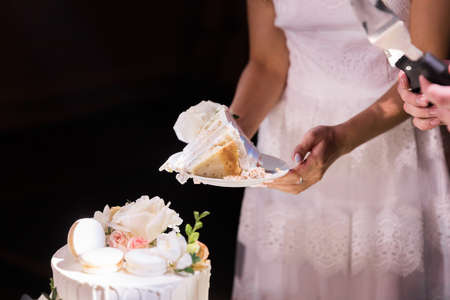 Cut A Piece Of Wedding Cake In The Hands Of The Bride And Groomの写真素材