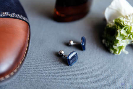 Blue cufflinks, boutonniere, toilet water and groom's shoesの写真素材