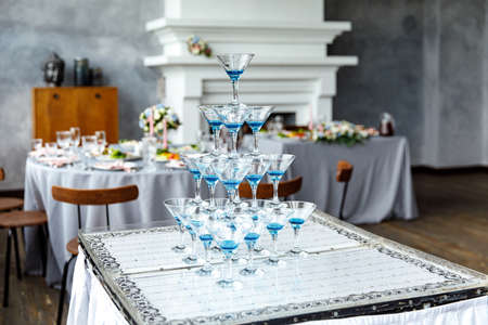 Champagne glasses. Wedding slide champagne for bride and groom. Colorful wedding glasses with champagne. Catering service. Catering bar for celebration. Beauty of bridal interior for weddingの写真素材