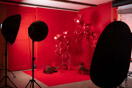 Photo studio interior with group of red heart shaped balloons, gifts and red rosesの写真素材