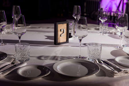stylish empty glasses and plates at setting at elegant table for wedding reception, catering in restaurantの写真素材