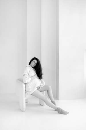 Pregnant brunette girl in an oversized knitted sweaterの写真素材