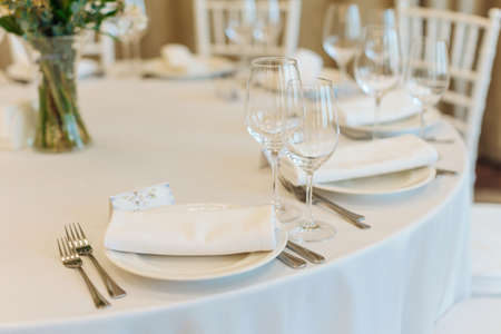beautifully set tables with glasses and appliances for a wedding or other event