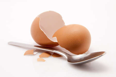 breakfast shell of an egg with spoon isolated on white background