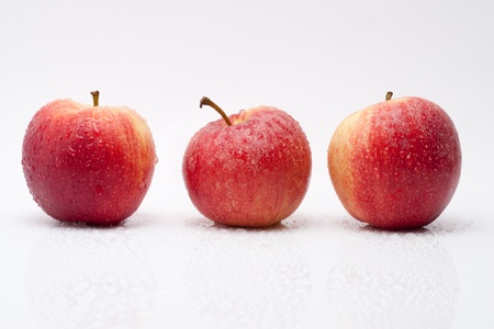 juicy sweet red apples with water drops isolated on white backgroundの写真素材