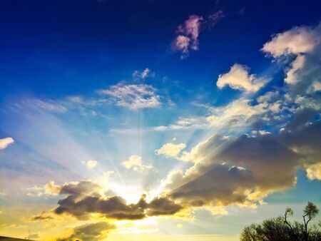 The sun bursting through clouds.の素材