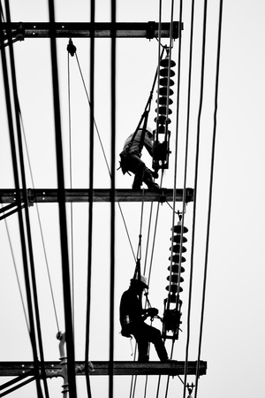silhouette electrician working on electricity postの写真素材