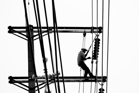 silhouette electrician working on electricity postの写真素材