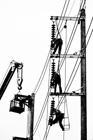 silhouette electrician working on electricity postの写真素材